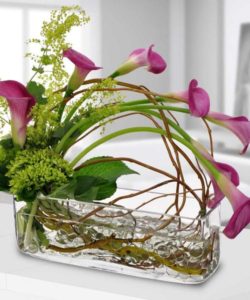 beautiful calla lilies and greenery in rectangular vase