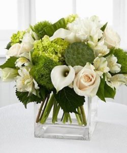 Inspire them with pristine blooms bursting with radiant light. Garden Hydrangea, calla lilies, roses, lisianthus and Peruvian Lilies are perfectly beautiful accented wtih the lush vibrant greens. Seated in a clear glass square block vase, this bouquet offers peace and an exquisite charm your special recipient is sure to treasure.