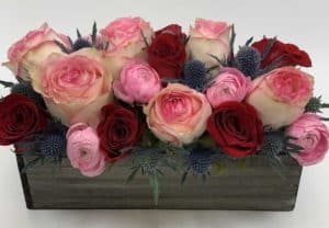Pink and Red Roses, pink ranunculus, thistle and moss arranged in our weathered wooden box.